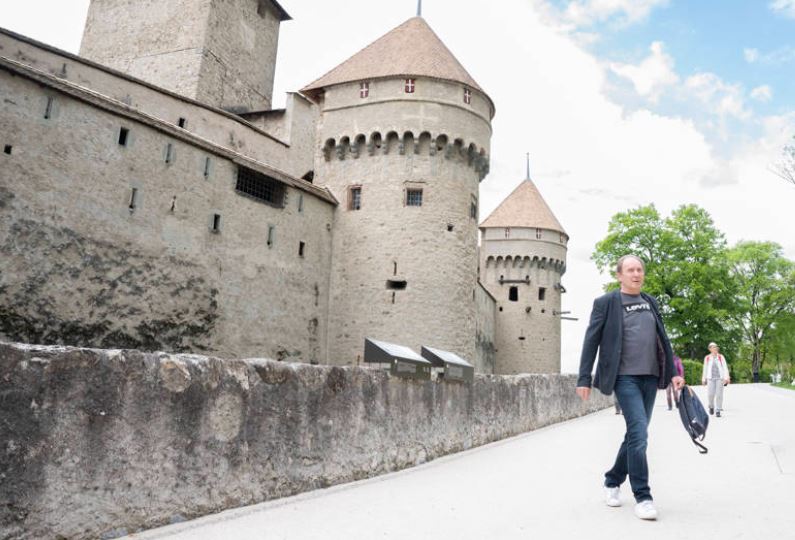 Persona con Parkinson caminando delante de un castillo.